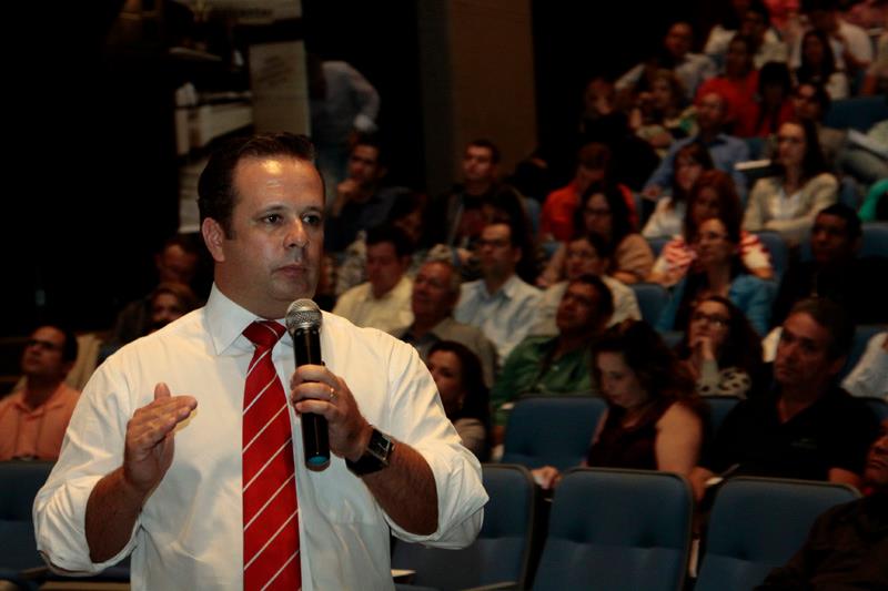 Palestrante conduzindo treinamento in company para colaboradores no auditório de uma empresa